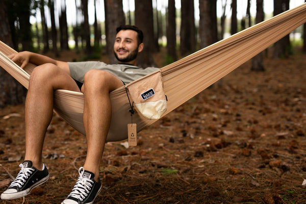 Sahara Sand recycled hammock with cream fabric and tan straps, displayed in forest setting with product tag visible