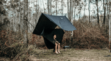 Woman in a Nakie hammock with a bugnet relaxing by the water. Nakie - Australia