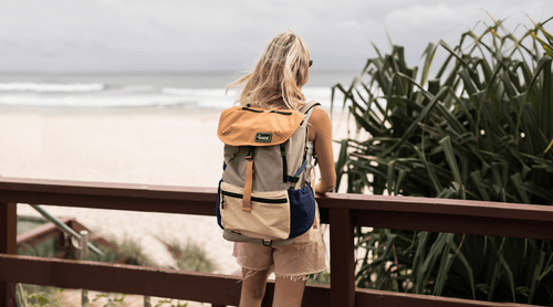 Man hiking in forest with sustainable Nakie backpack made from recycled plastic bottles, ideal eco-friendly hiking gear