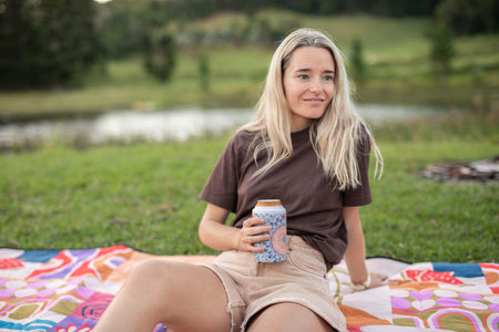 Sound of Summer Cooler & Coffee Cup holding a can at a picnic