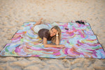 Recycled picnic blanket with multicolored swirl pattern in pink, purple, blue, and green laid out on sand. preview #10