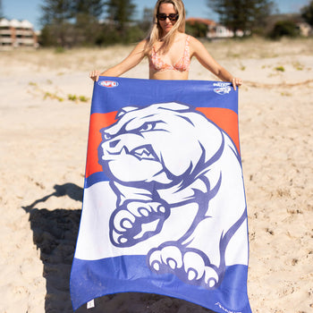 Western Bulldogs AFL beach towel in blue and orange with white bulldog logo, sand-free microfiber material, displayed on beac