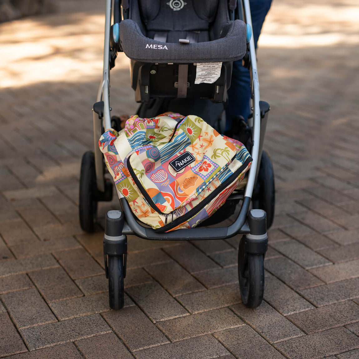 Retro Shores recycled tote bag with colorful sun and wave print displayed in stroller basket, front view