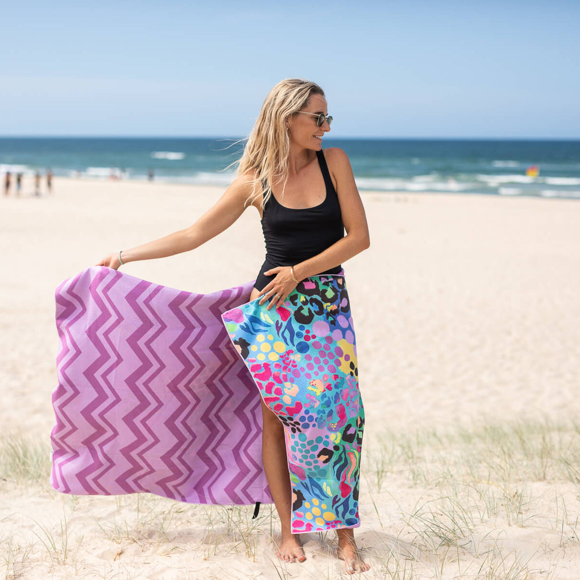 Purple chevron and multicolored patterned recycled sand-free beach towel held on beach