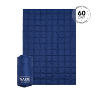 Studio shot of Nakie's Deep Ocean Blue puffy blanket, showcasing its cozy warmth and eco-friendly design, perfect for outdoor adventures and cozy nights.